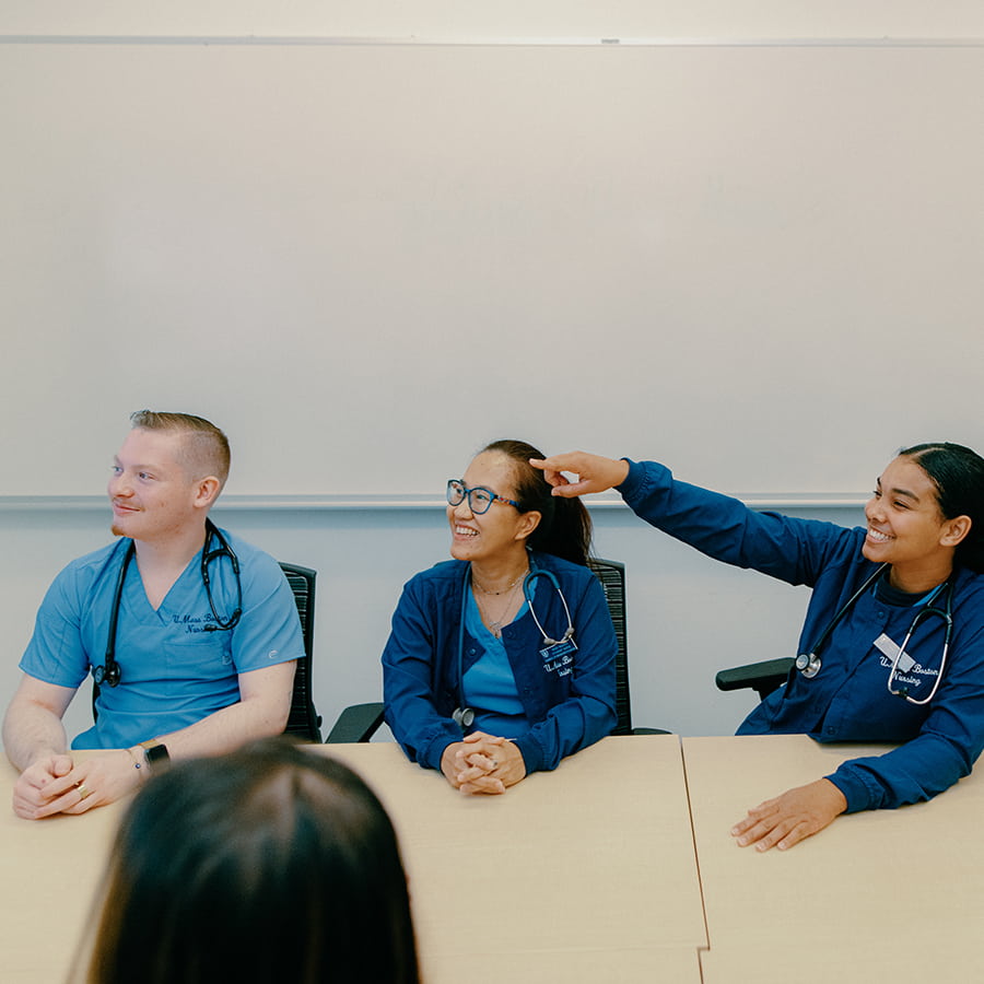 Nursing students in scrubs take a seminar.