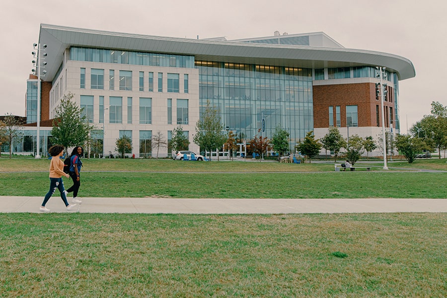 2 students walk in front of University Hall.
