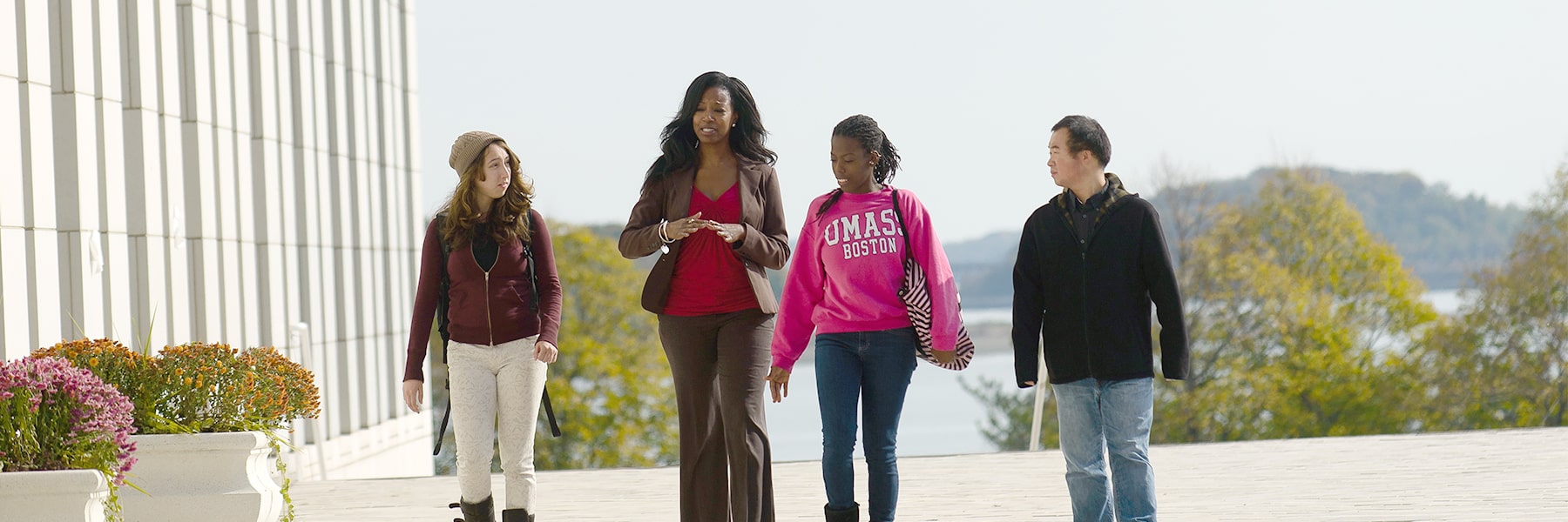 Students walk with a financial aid counselor on the plaza.