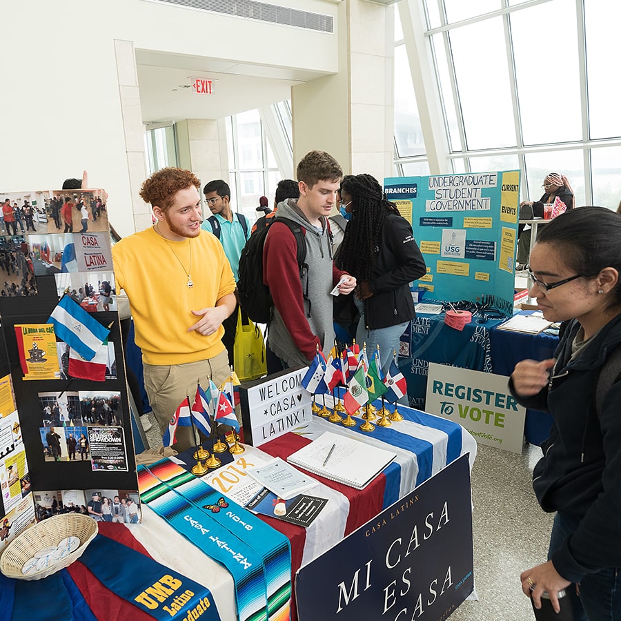 Student tables for club with banner reading mi casa es su casa and flags from Spanish speaking countries.