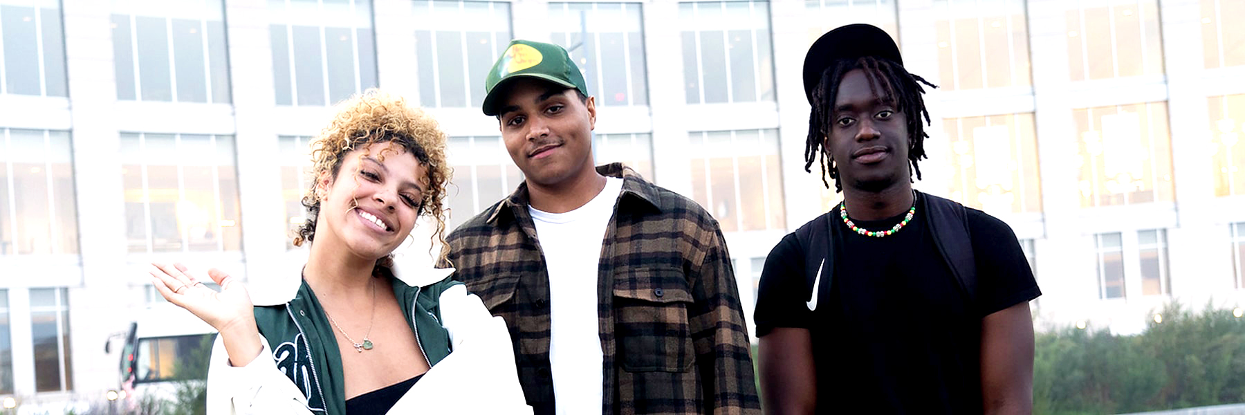 Three students pose outside of the campus center