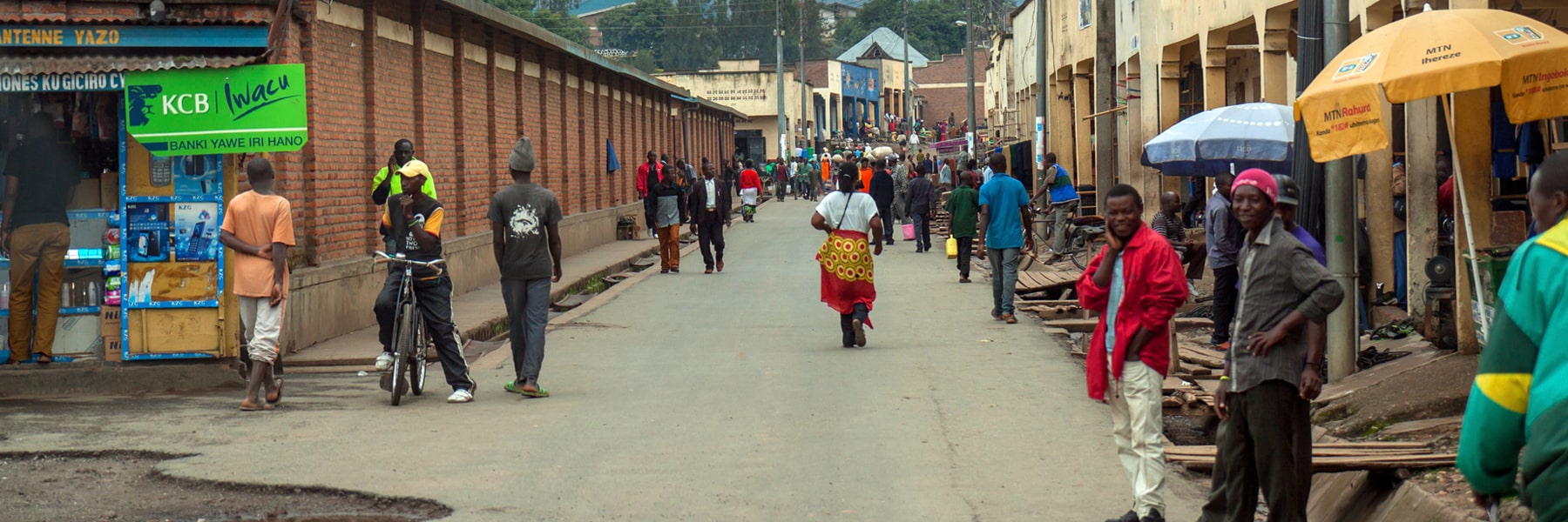 Mahoko, Rubavu, Rwanda: main street on market day with many people entering the town, the cloudy sky indicates that the rainy season has started.