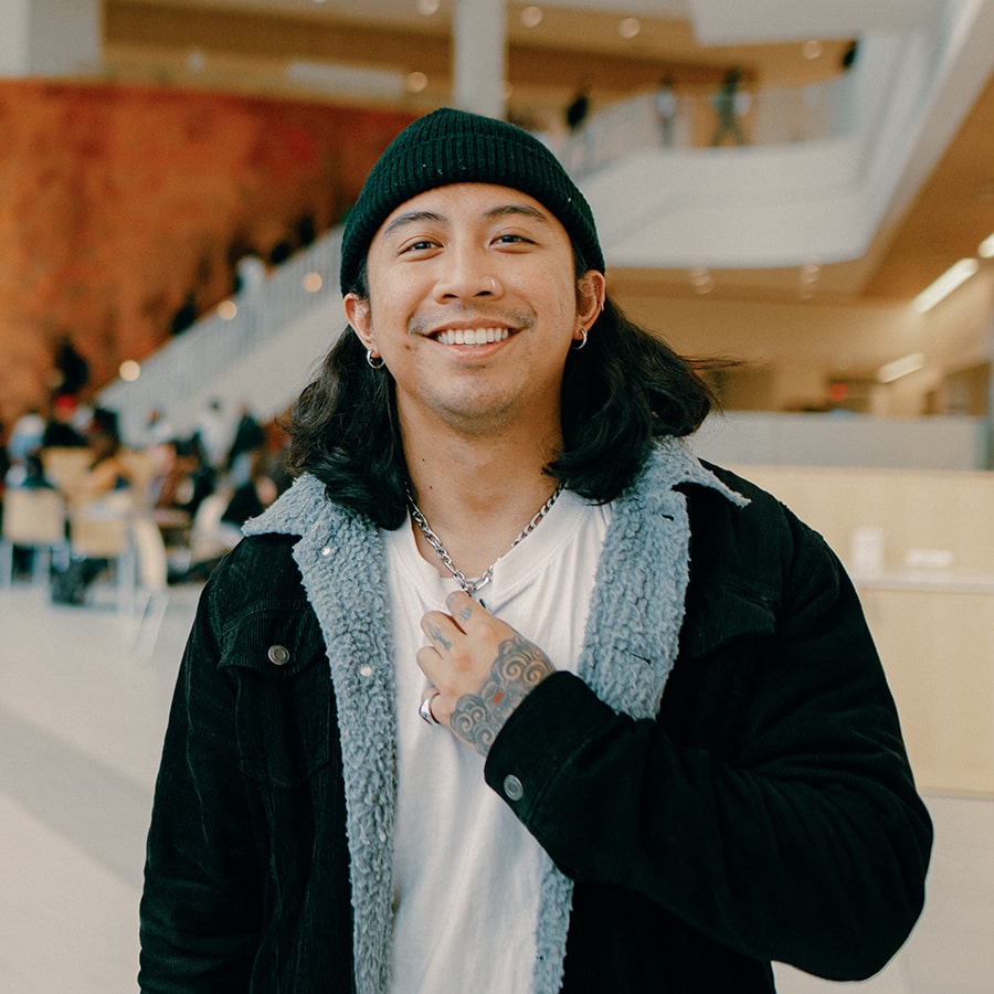 Harley smiles standing in Uhall lobby.