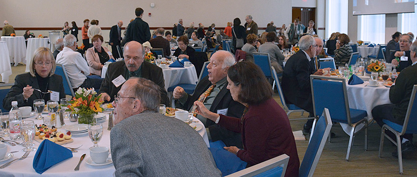 Retired faculty luncheon, sitting at tables eating.