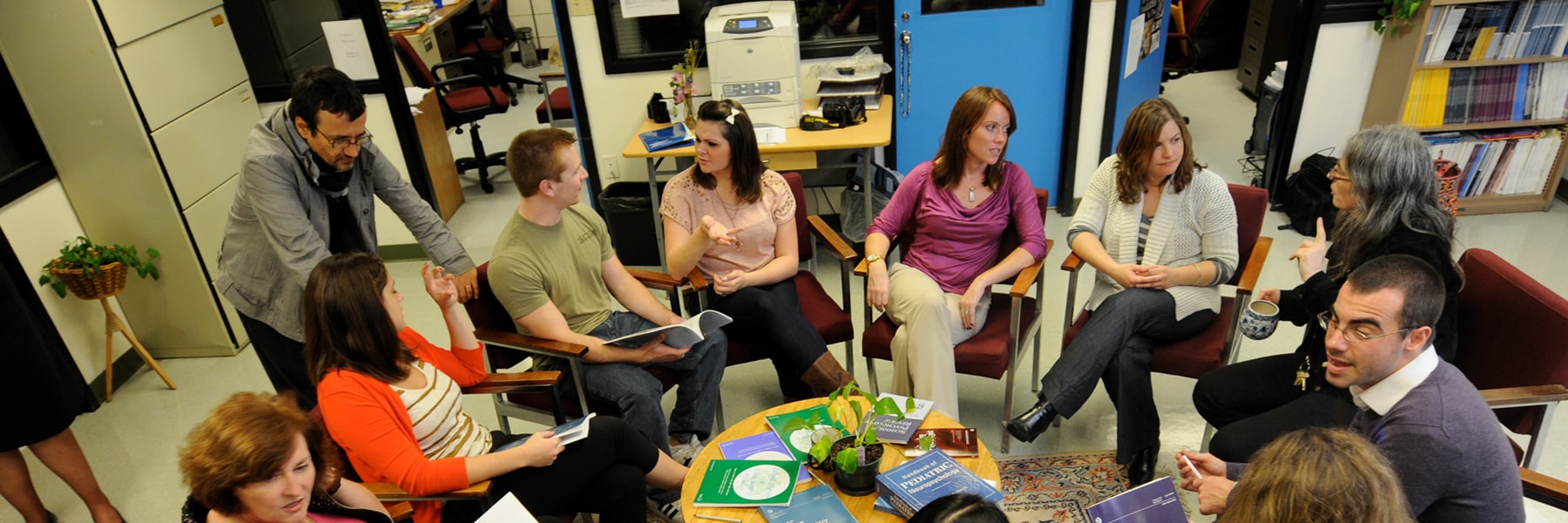 counselors sitting around a small circular table with pamphlets on it