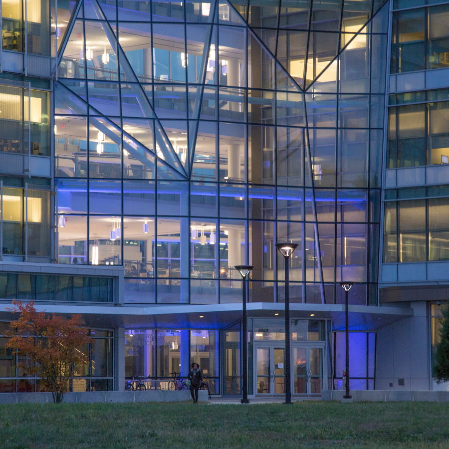 Night view of the Integrated Sciences Complex showing purple lights in building.