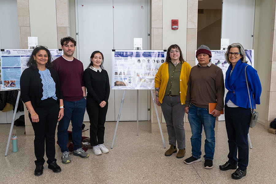 Professor Sowmya Balachandran's class stands with their poster describing their work on affordable housing innovation